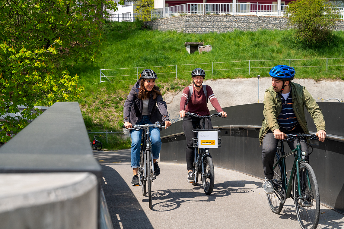 3 Leute auf Velos auf einer Velobrücke